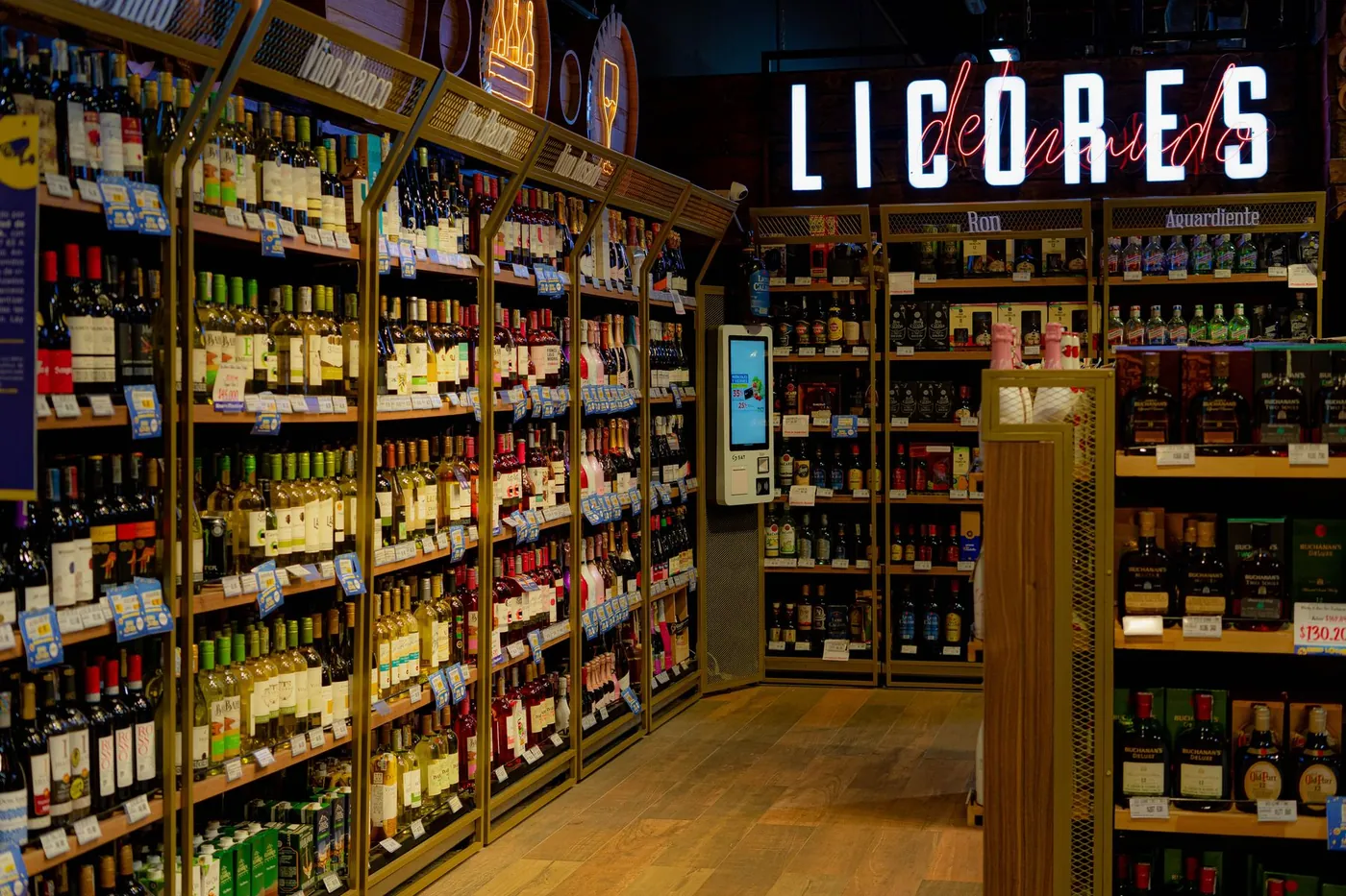 Pasillo de la botillería con estantes de vinos y licores